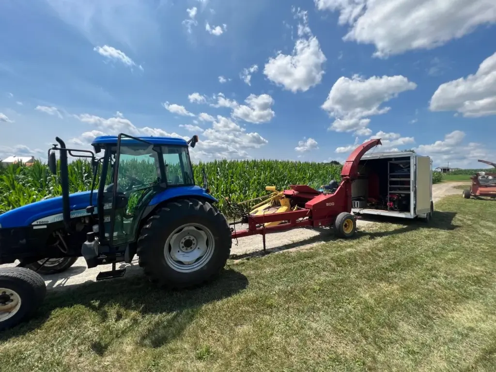 a blue tractor and a red New Holland 900