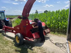 a red New Holland 900 and a blue tractor at Country Machinery